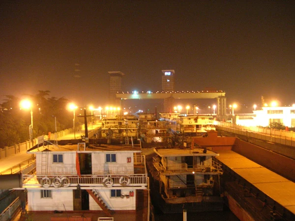 Gezhouba-Talsperre: die Schiffsschleuse bei Nacht, Tore und Gebäude hell erleuchtet.