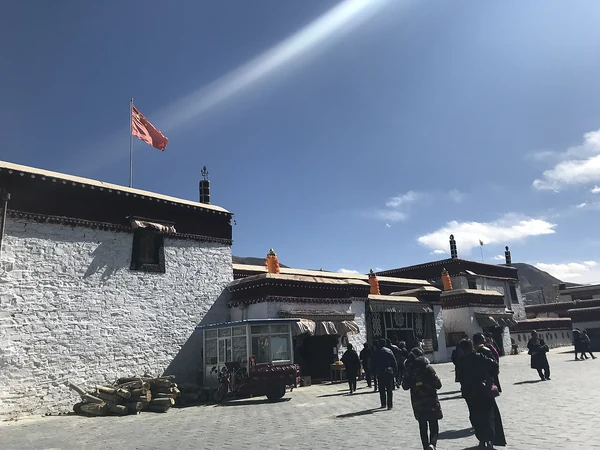 Varias personas están en un patio bajo los tejados de Tradruk.