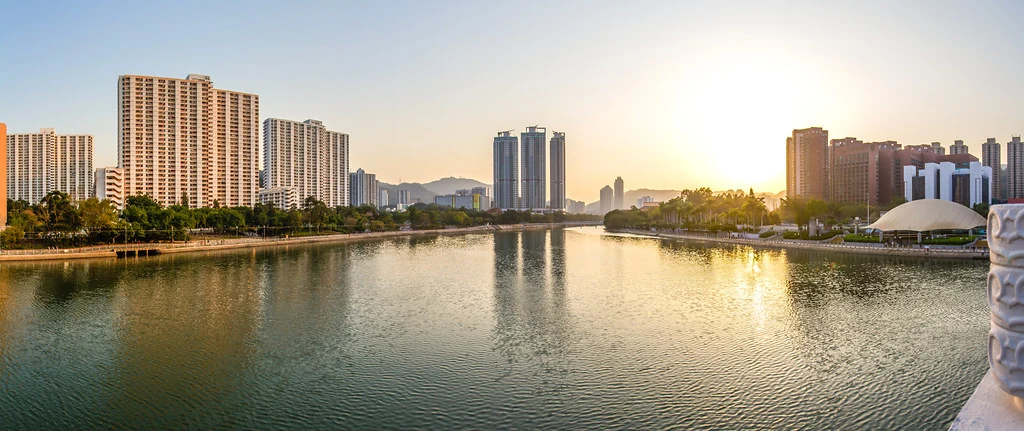 Coucher de soleil sur la rivière Shing Mun et les immeubles riverains de Sha Tin.