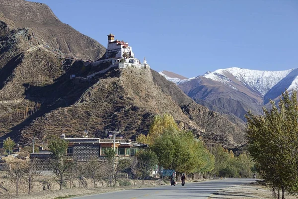 La torre y los muros de Yumbulagang se elevan por una cima estrecha.