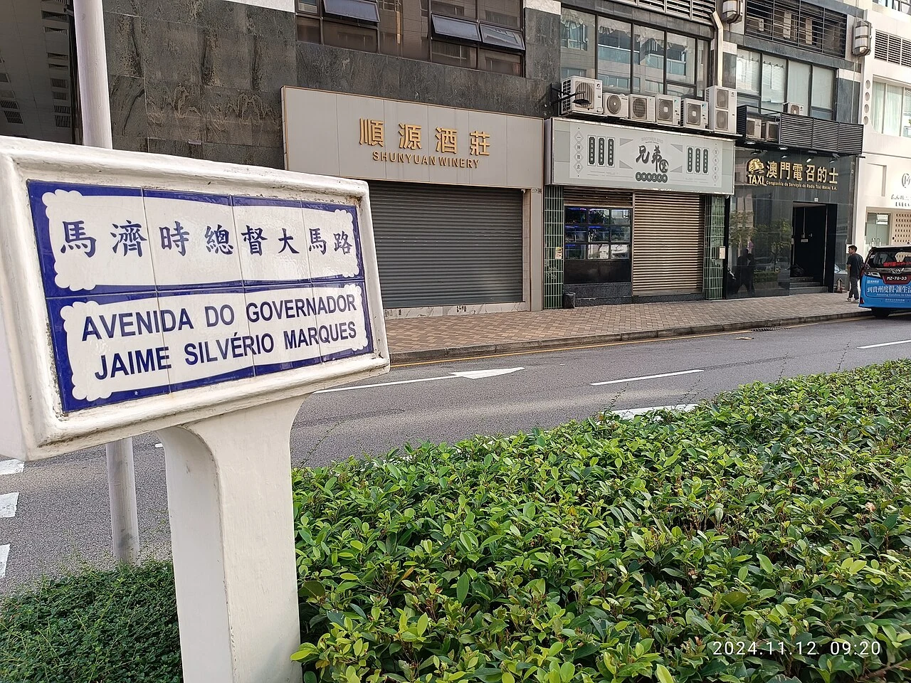 Une plaque de rue bilingue bleue et blanche à Macao.