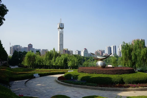 Daye: el monumento del Reloj del Siglo en el parque cívico, una alta torre de reloj junto al lago.