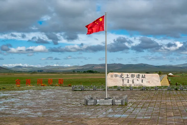 元上都遗址前的石碑，远处是草原。