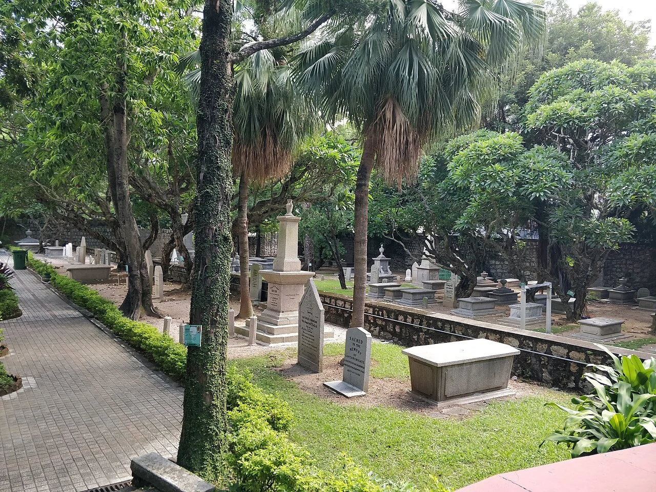 Grabstätten und Bäume auf Macaos altem protestantischem Friedhof.