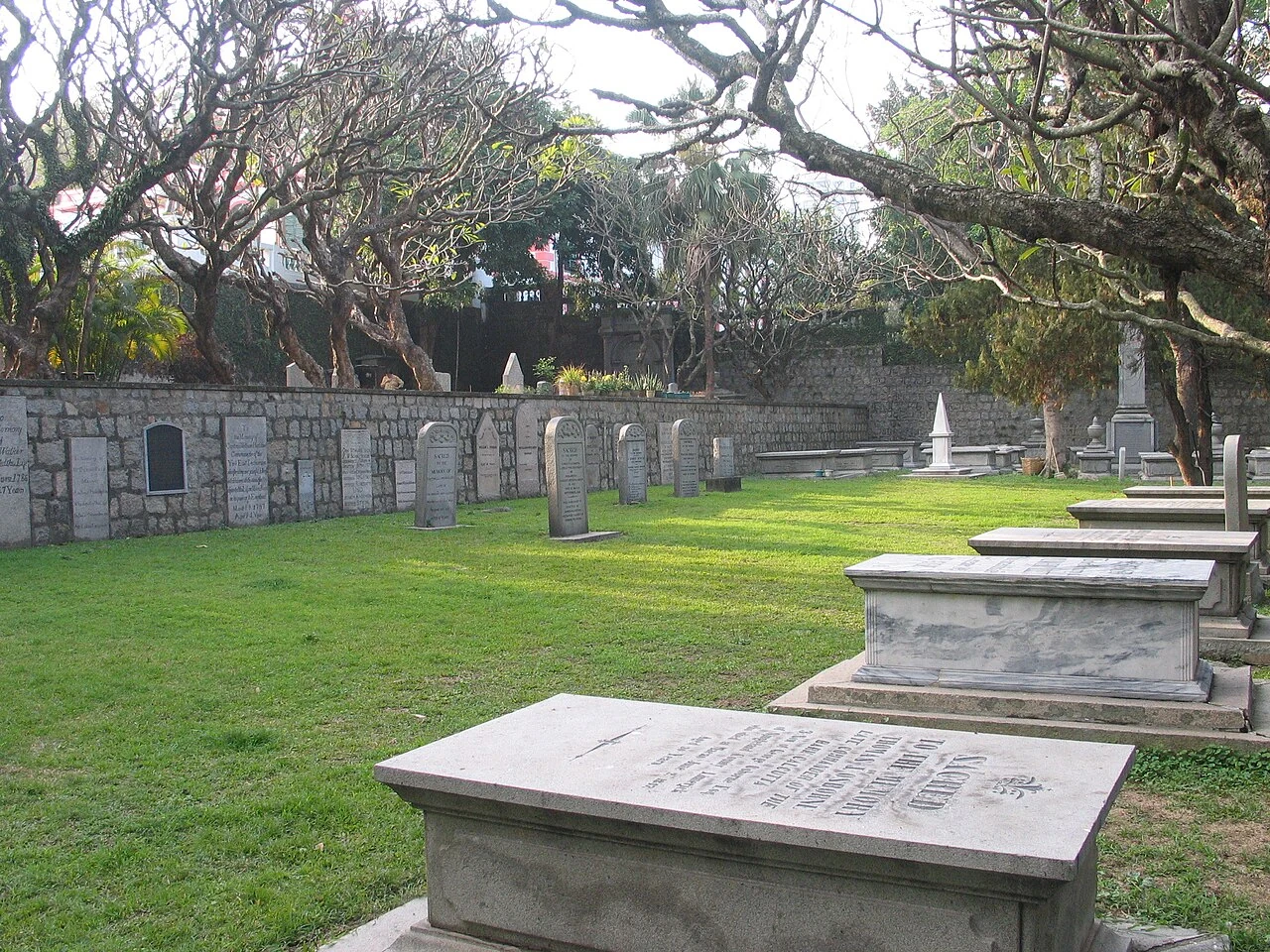 Grabstätten und Bäume auf Macaos altem protestantischem Friedhof.
