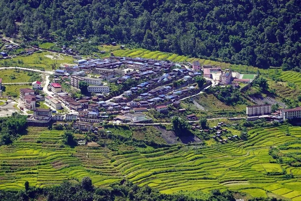 Blick von oben auf das Dorf Beibeng, die Felder und die bewaldeten Talhänge.