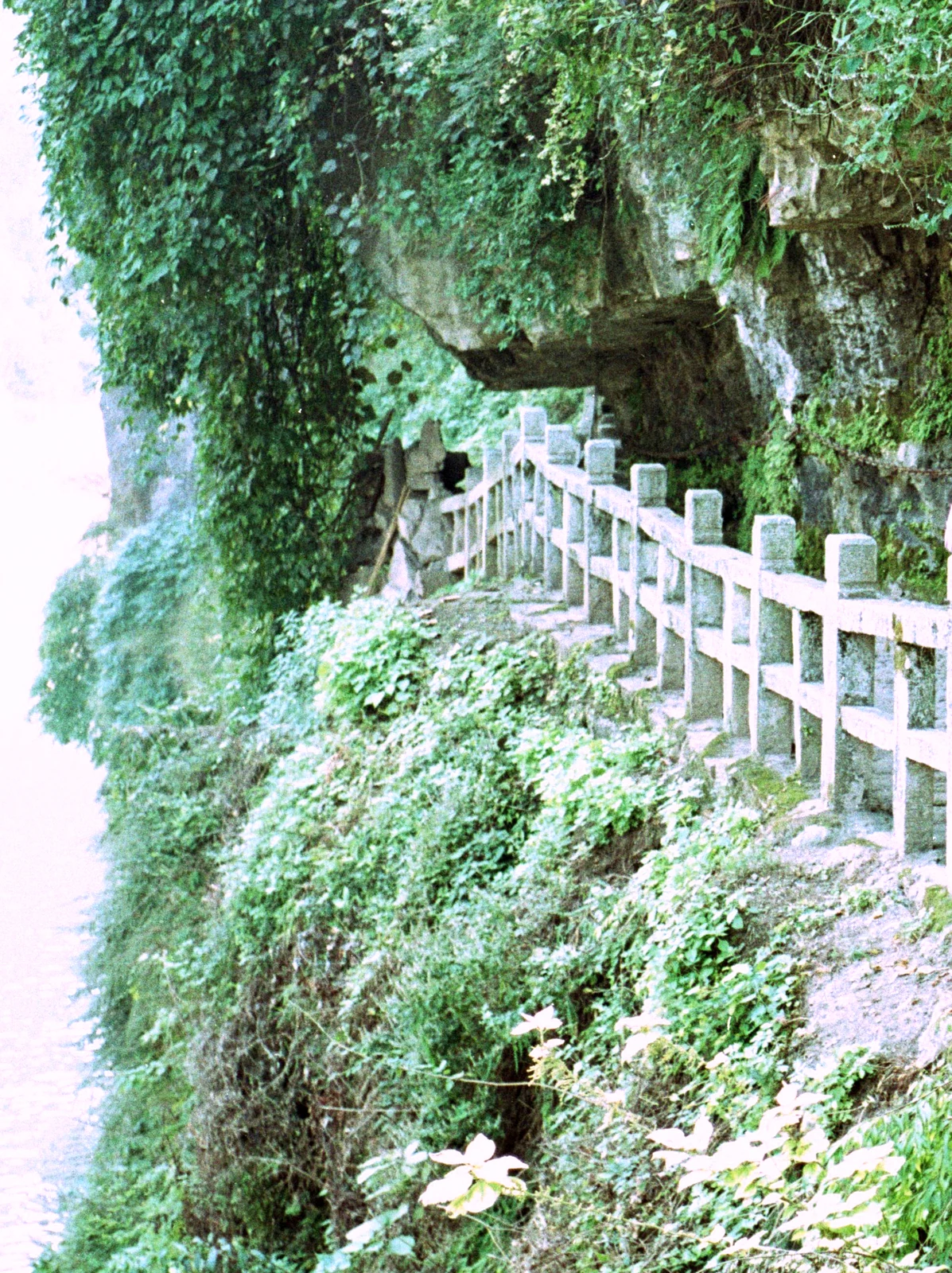 Grotte de Sanyu : la passerelle de bois à balustrade blanche, grimpant jusqu'à l'entrée de la grotte.