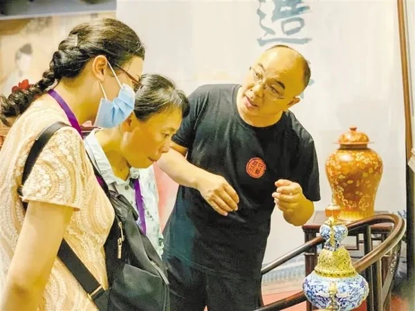 王晟在展品前向兩位參觀者講解。