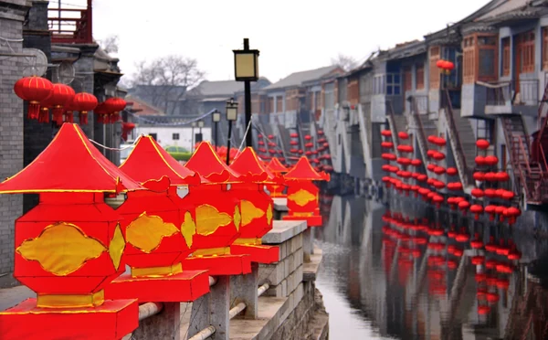 灰磚建築之間的水道兩側排列著紅燈籠。