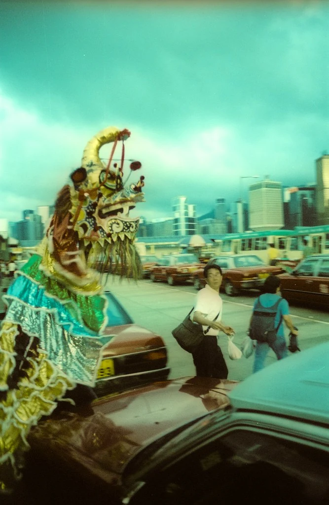 Una figura de danza del dragón pasa junto al embarcadero tras el Jiao de Cheung Chau en 1997.