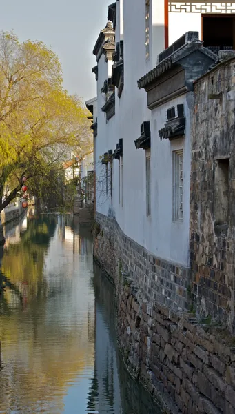 Whitewashed houses with dark tiled roofs rise directly from a canal beside Pingjiang Road.