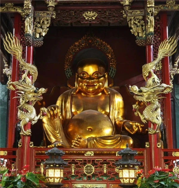 Maitreya en la Sala de los Reyes Celestiales: una amplia sonrisa y un vientre redondo reciben al visitante en la entrada.