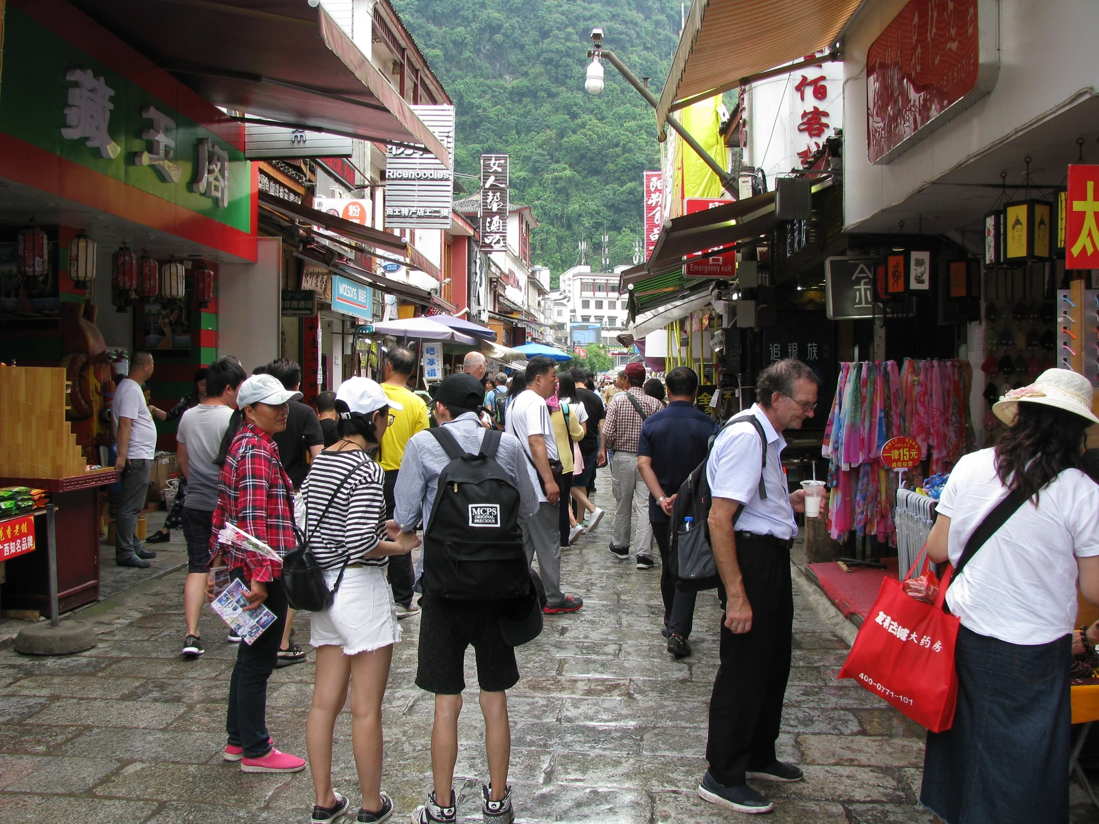 Una multitud llena la Calle Oeste de Yangshuo entre tiendas y restaurantes.
