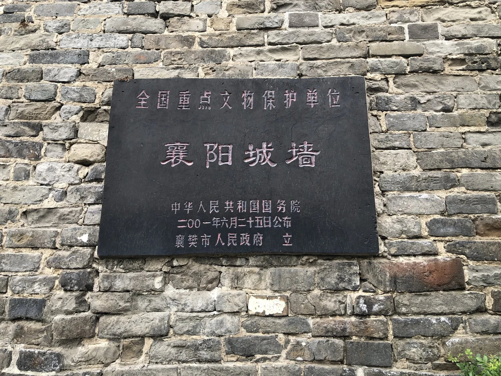Ville fortifiée de Xiangyang : la plaque de patrimoine national encastrée dans le rempart de briques grises.