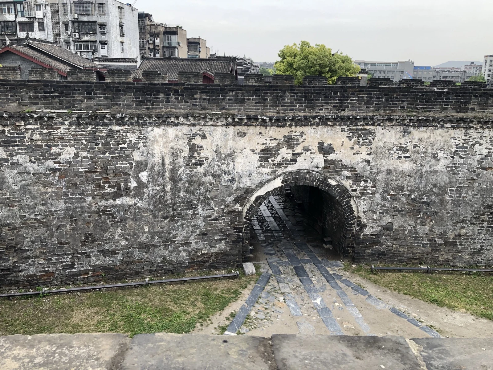 襄阳古城:城墙中的拱形砖砌门洞,后方是城墙与城区。