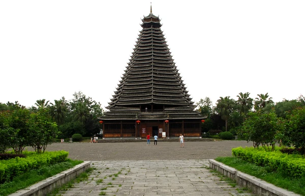 A tall, many-tiered drum tower rises above a paved square in Sanjiang.