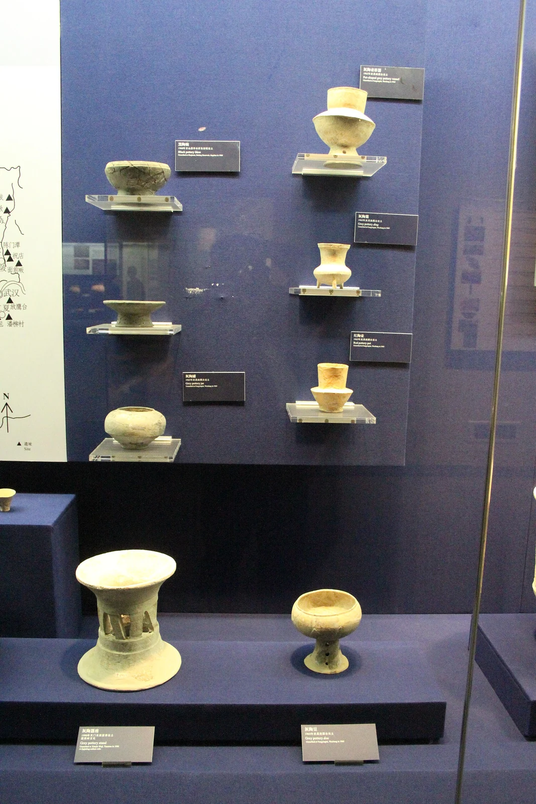 Qujialing: vessels of the culture arranged on tiered shelves in a display case.