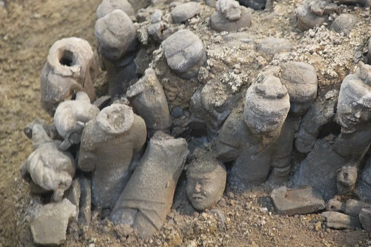 徐州一處土坑中，成排的小型出土陶兵馬俑仍嵌在土中。