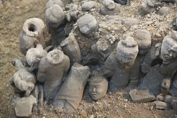 Rows of small excavated terracotta warriors remain embedded in an earthen pit in Xuzhou.