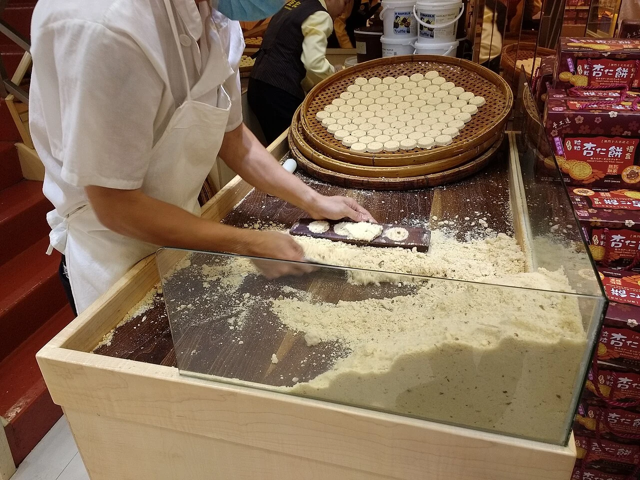Galletas de almendra en elaboración en Macao, con una bandeja y una superficie de trabajo a la vista.