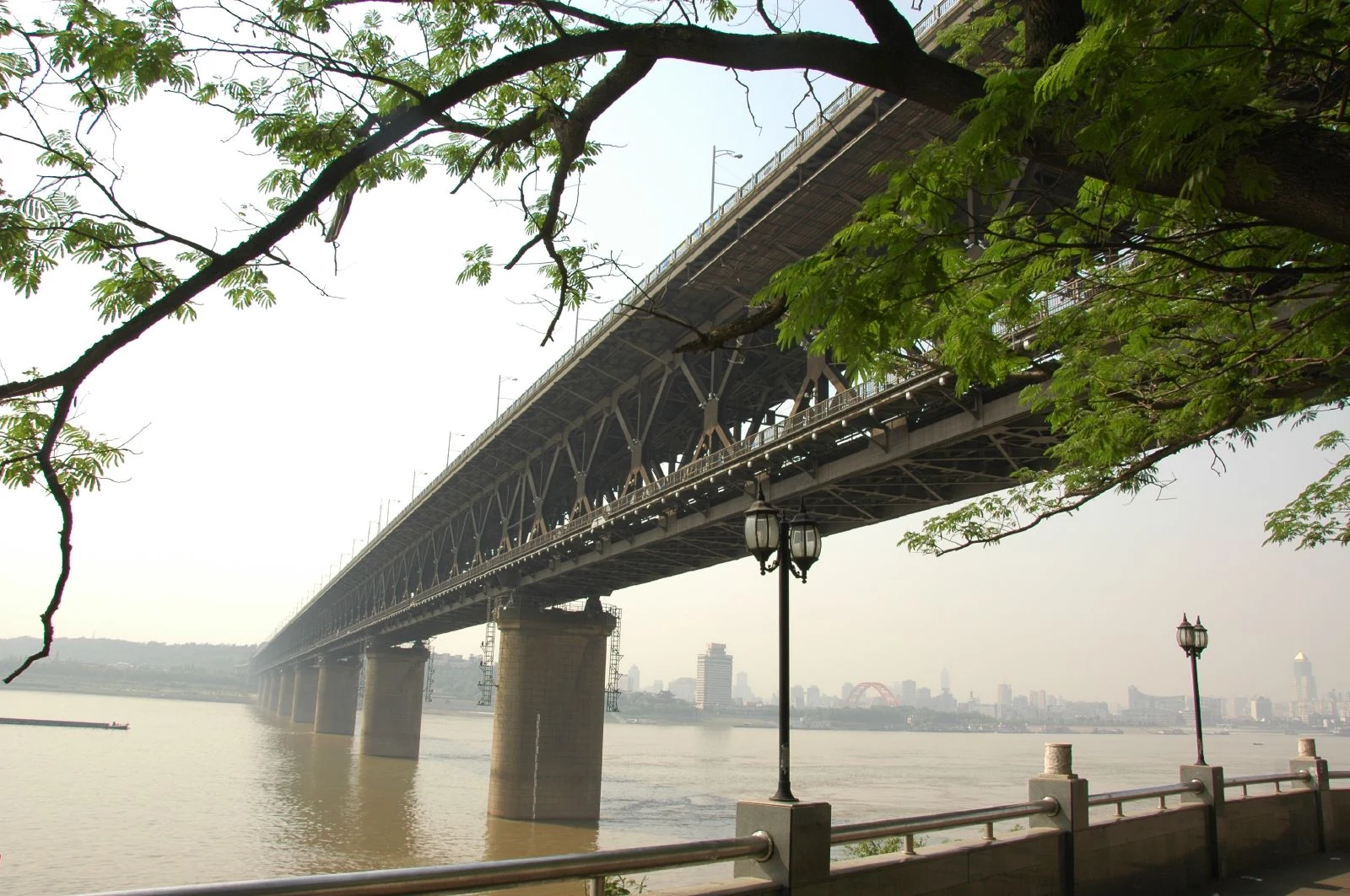 El puente del Yangtsé en Wuhan desde el paseo fluvial, con sus celosías de doble nivel sobre pilares de piedra.
