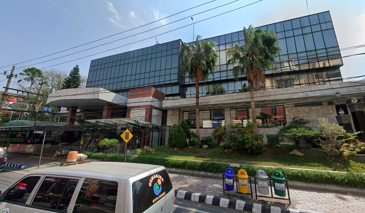 Qianjiang: the glass-fronted Buffalo Cinema, with palm trees and the street in front.