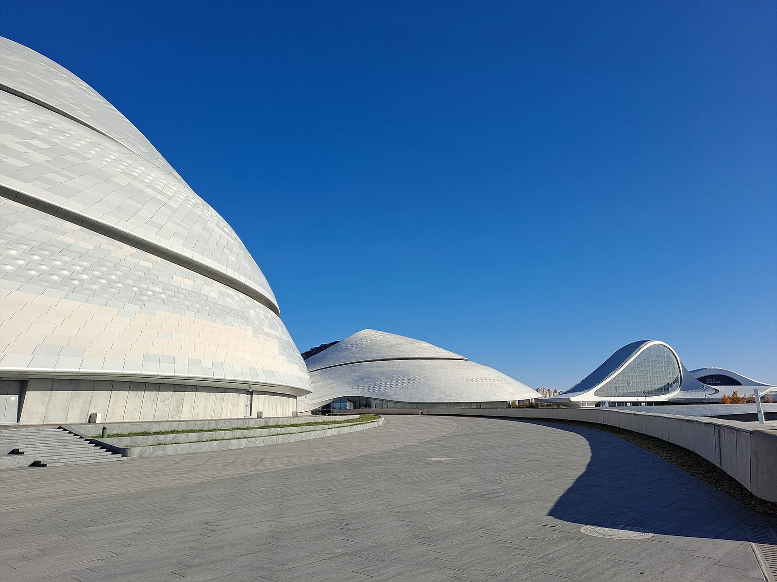 Weg entlang der geschwungenen Fassade des Opernhauses Harbin