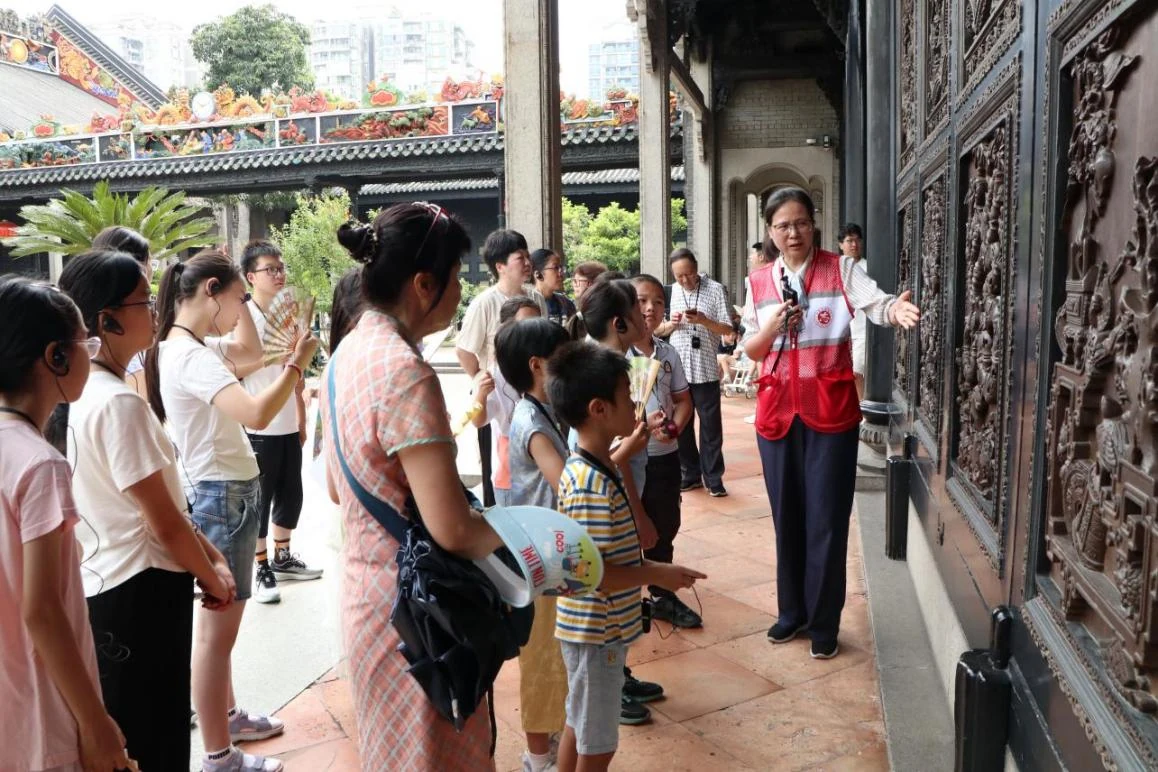 Visitantes observan los elementos arquitectónicos tallados de la Academia del Clan Chen