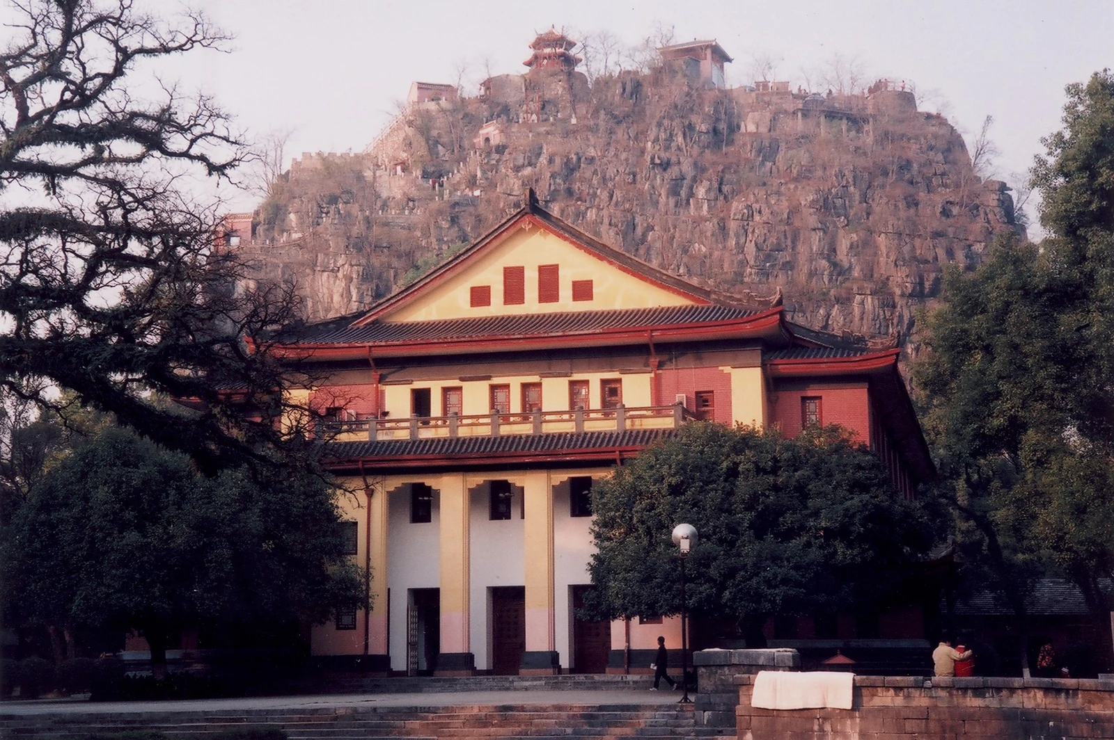 Le pic Duxiu s’élève derrière un grand bâtiment et une cour à Guilin.