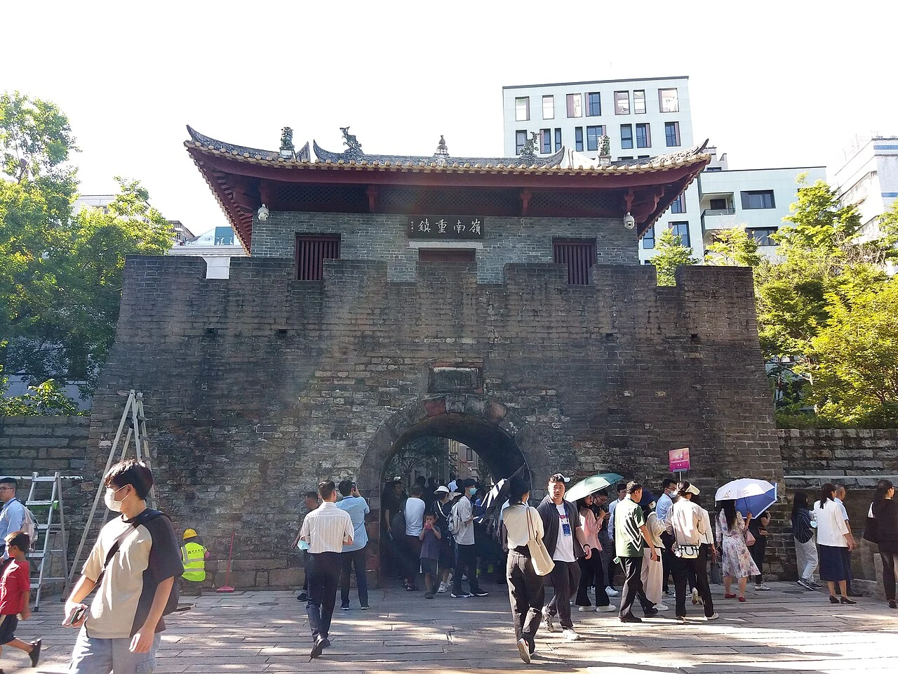Besucher gehen unter dem Torhaus der alten Stadt Nantou hindurch.