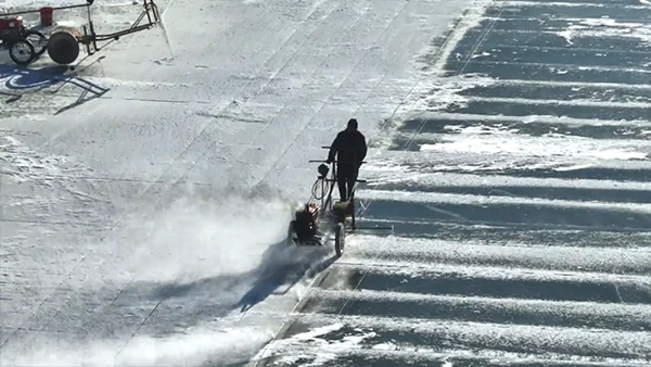 Arbeiter mit einer Säge am markierten Flusseis
